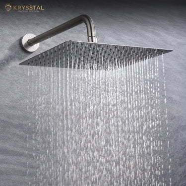 A Silver Shower head with water flowing against a gray background