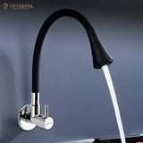 A wall-mounted kitchen sink tap with flowing water & a dual-flow feature and a black silicone spout on a purple background.