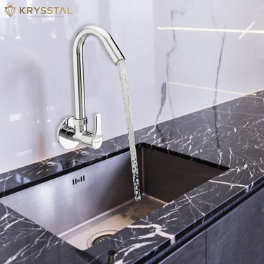 A polished chrome swan-neck faucet with a single-lever handle installed above a deep, modern kitchen sink.