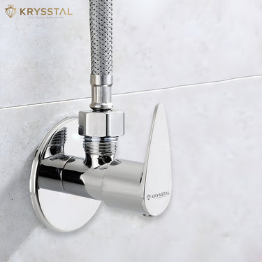 A chrome angle valve with a polished metallic surface and a fitted pipe on an upper hole and fitted on a white wall.