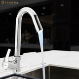 A polished chrome kitchen faucet with a gentle gooseneck curve, with water running into the sink on a black faded background.