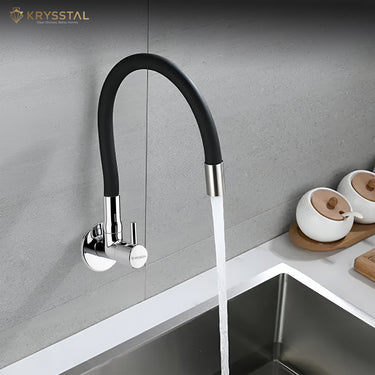 A grey wall-mounted kitchen sink tap with a flexible silicone spout with a water pouring on a stainless steel sink and a chrome finish.
