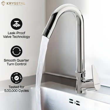 A chrome deck-mounted kitchen faucet with a curved high-arc spout running water into a stainless steel sink, highlighting its features: Leak-Proof Valve Technology, Smooth Quarter Turn Control, and Tested for 5,00,000 Cycles.