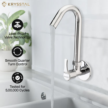 A shiny chrome faucet on a marble wall pouring water into a stainless steel sink, emphasizing the fixture's minimal design.