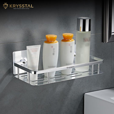 Medium silver wall shelf tray with face wash, two shampoos, and one deodorant on a grey wall.