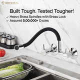 Dual-control chrome kitchen mixer tap with a flexible spout "Built Tough & Tested Tougher" tag, mounted on the wall above the sink.