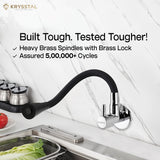 Stylish wall sink tap with dual spray feature and black silicone flexible spout fitted on a white marble wall with SS sink on the bottom.
