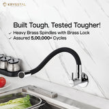 Silver kitchen sink mixer tap mounted on the white texture wall, featuring a flexible silicone spout with "Built Tough Tested Tougher!" tag on the top