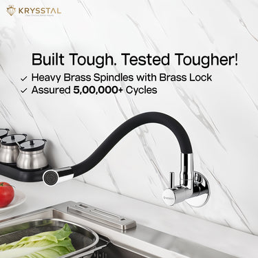Silver kitchen sink mixer tap mounted on the white texture wall, featuring a flexible silicone spout with "Built Tough Tested Tougher!" tag on the top