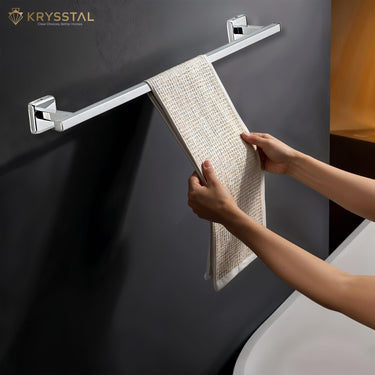 A hand-held towel hanging on a silver stainless steel towel rod with mounting brackets against a black background.