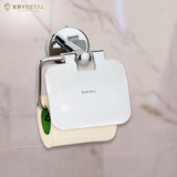 A silver SS toilet paper holder with a round design with paper holding on it & fixed on a white textured wall.