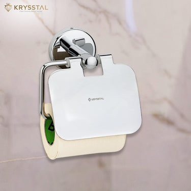 A silver SS toilet paper holder with a round design with paper holding on it & fixed on a white textured wall.