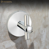 A silver stainless steel robe hook with a round backplate and a vertical crossbar fitted on a grey wall.