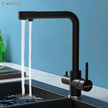 Black faucet with water flowing into a sink against a blue wall, featuring the Krysstal brand.