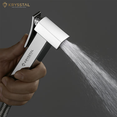 Shower head with water spray held by a hand, Krysstal brand visible