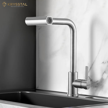 Modern kitchen faucet fitted on a stainless steel sink with marble backsplash and Krysstal branding