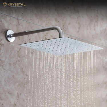 A silver overhead rain shower with straight water flowing from it fitted on a tile wall