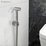Chrome handheld shower head mounted on a tiled wall with Krysstal branding.