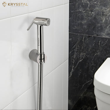 Chrome handheld shower head mounted on a tiled wall with Krysstal branding.