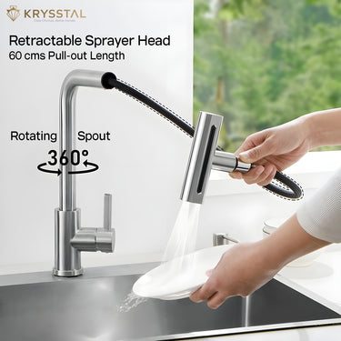A kitchen faucet with retractable sprayer head and rotating spout, hand-held by a person washing dishes on a white & green background.