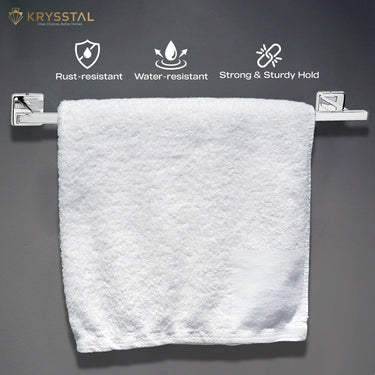 The white towel hanging on a silver stainless steel towel rod shows 3 benefits on top on a grey wall and is placed against a black background.