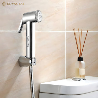 A silver health faucet shower on a wall hook on a tiled background.