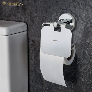 A silver toilet paper holder with a round design with paper holding on it fitted on a black textured wall beside the white toilet seat.