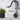 A black finish flexible dual flow kitchen sink tap watering the plant pot with hand shower & piano keys for outlet activation mounted on a white wall