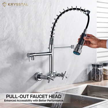 A silver hand-held pull-out faucet head with dual controller in a kitchen setting with water flowing.