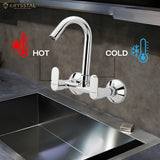 A chrome finish kitchen sink mixer tap with a hot & cold controller features mounted on the wall above the sink.