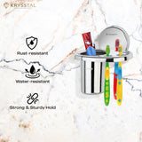 A silver toothbrush holder fixed on a white tile surface holding 3 colorful toothbrushes & 1 paste with its feature on the left side.