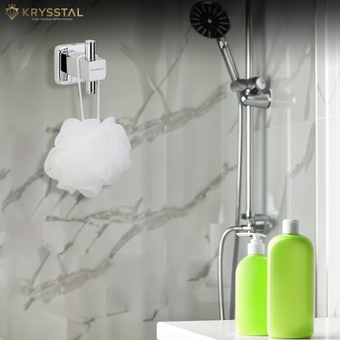 Square stainless-steel robe hook with white scrub, placed on vertical rod near wall shower, sink, green soap dispenser, and bottle.