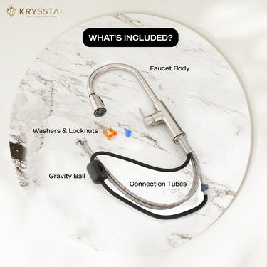 The silver matte finish Kitchen Sink mixer tap with included its components like connection tubes, gravity ball on the white textured circular slab on a white background.