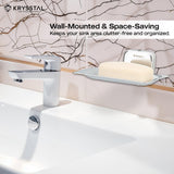 A space-saving silver square soap dish holding soap, reflecting on the holder, on a white textured wall, with white washbasin with silver tap at the bottom