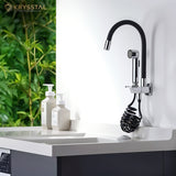 Black flexible kitchen faucet with dual flow and detachable hand shower, isolated on white wall above the sink beside the 2 dispenser.