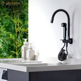 Matte black piano kitchen faucet featuring a hand shower, isolated on white wall.