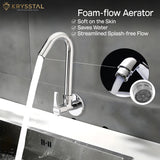 Highlighted detail of a foam flow aerator chrome mixer providing water flow into a sink set in black and white marble.