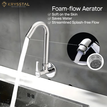 Highlighted detail of a foam flow aerator chrome mixer providing water flow into a sink set in black and white marble.