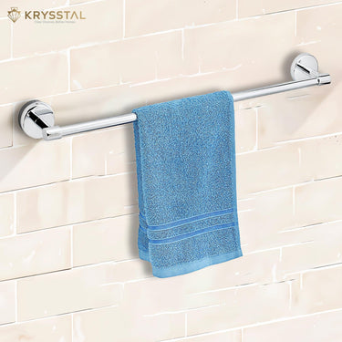 A silver stainless steel towel rod with a polished finish & circular end caps with a hanging blue towel on it fixed on a beige tile.