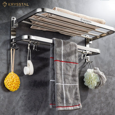 Silver towel rack with a hanging a towel & others things mounted on a black matt wall.