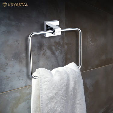 A white towel hanging on a silver stainless steel square towel ring with a square mounting on the grey wall.