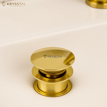 Gold Pop-up bath drain on a beige background