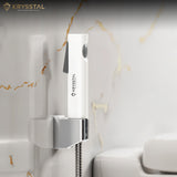Wall-mounted shower head with Krysstal branding against a white marble wall.