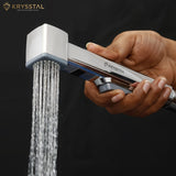A silver-colored handheld White ABS Health Faucet shower with water flowing on a dark background